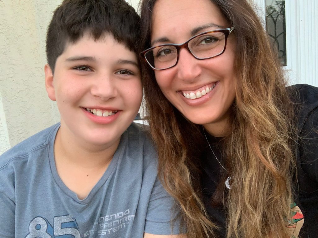 Son and mom sitting together outside on the steps.